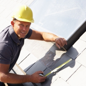a roofer putting shingles on a house